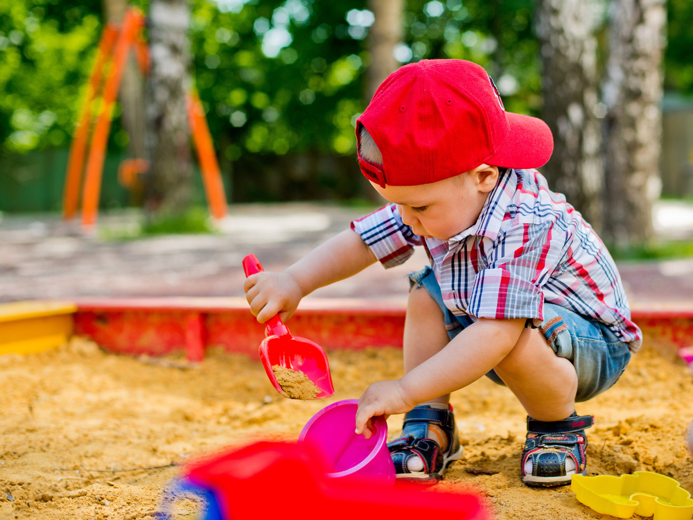chlapec hrajuci sa s pieskom na pieskovisku skolka montessori jasle
